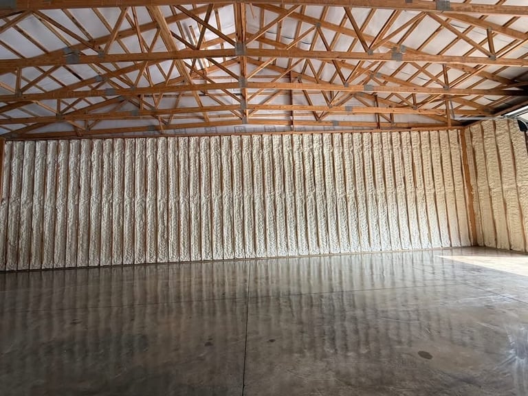 Empty industrial warehouse interior with exposed wooden beam roof structure and metal corrugated walls